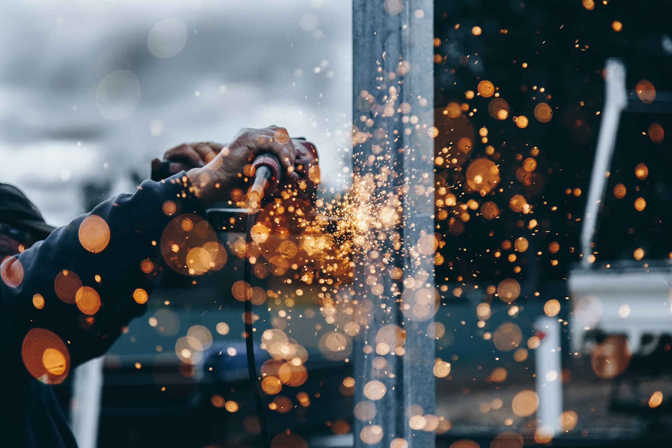 Craftsperson grinding steel with sparks flying